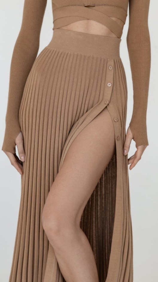 A stylish pleated midi skirt offers a perfect mix of comfort and fashion for fall, establishing it as a fashionable selection for the season.