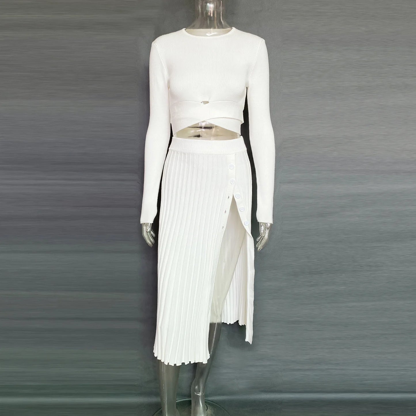 Get ready to fall in love with the 'Tossy'—a chic, white knit two-piece set for women. This ensemble features a ribbed crop top paired with a pleated midi skirt, perfect for those crisp autumn days. It's the ultimate blend