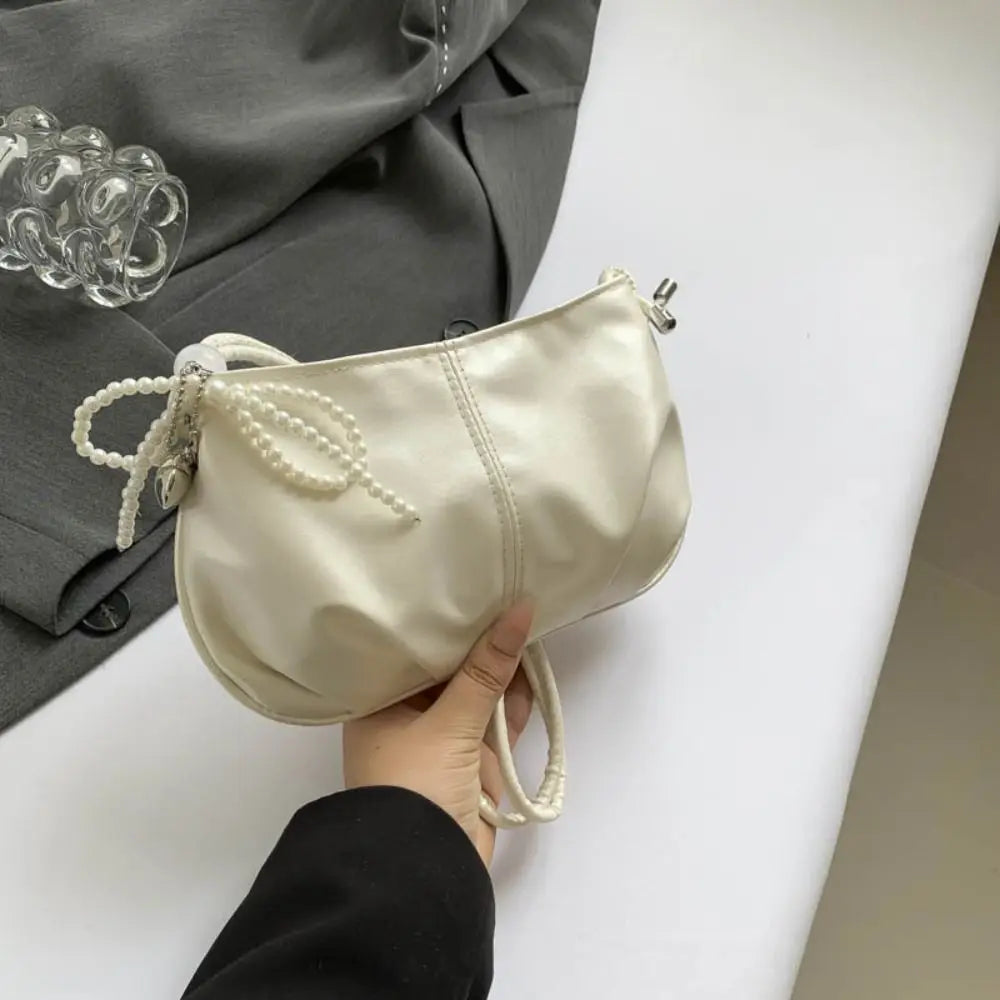 **"Pearlescent Underarm Tote with Bowknot & Pearl Accents"**  
Elevate every outing with Tye Meshun's pearlescent underarm tote. Featuring a charming bowknot detail, a whimsical pearl pendant key ring, and a sleek Y2K-inspire