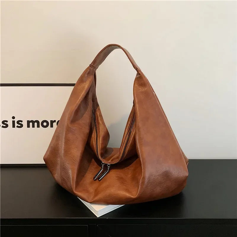 **"Bold Leather Shoulder Bag"**  
Add excitement to your everyday look with Tye Meshun's bold leather shoulder bag. Its roomy hobo design and luxurious craftsmanship make it as functional as it is stylish. Perfect for travel,