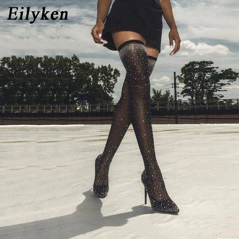 Eilyken Design features crystal rhinestone-adorned, stretch fabric high heels that are both sexy and elegant. These over-the-knee boots with a pointed toe silhouette are a statement piece for any wardrobe.