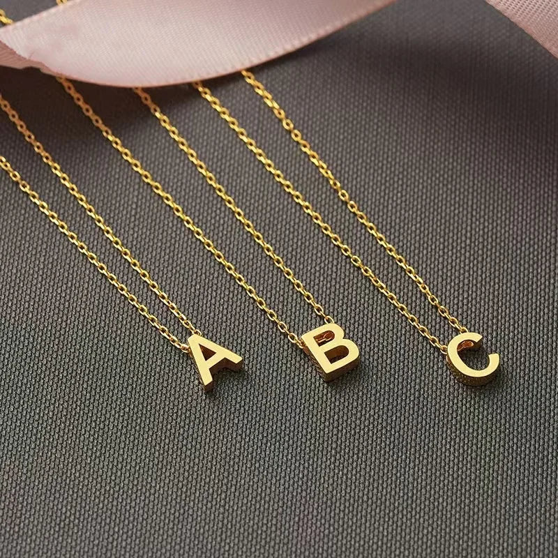 **"Stainless Steel Initial Necklace"**  
Hand-selected for Tye Meshun's Boutique, this gold-tone choker features cut letters for a personal touch. Perfect for layering or gifting, it’s a timeless statement piece.