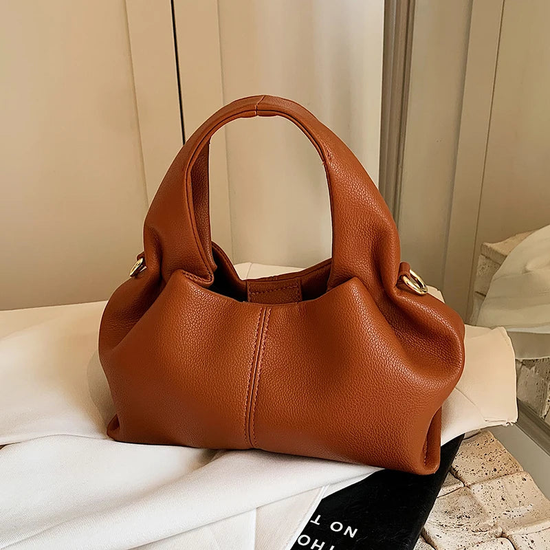 Here’s a season- and date-neutral version:

**"Women's Dumpling Shoulder Crossbody Bag"**  
Elevate your look with Tye Meshun's luxurious top-handle hobo bag. Featuring a chic "dumpling" silhouette, this versatile piece tra