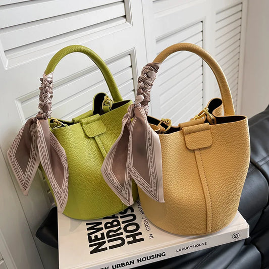 **"Bucket-Style Crossbody Bag"**  
This soft-colored, high-quality bucket bag, handpicked for Tye Meshun's boutique, features inner compartments and sleek stitching. Perfect for commuting or casual wear, it blends practicalit