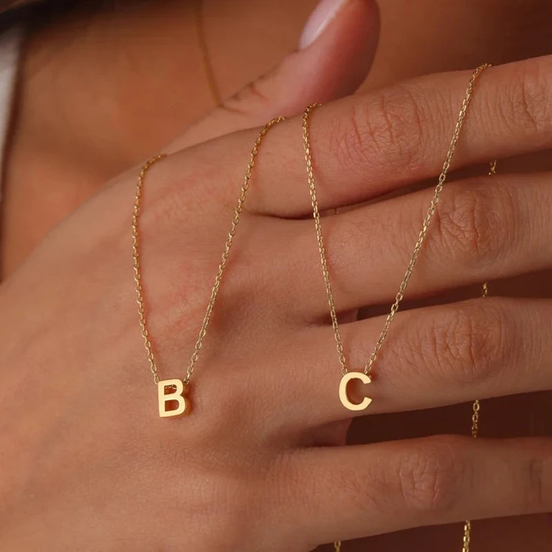 **"Stainless Steel Initial Necklace"**  
Hand-selected for Tye Meshun's Boutique, this gold-tone choker features cut letters for a personal touch. Perfect for layering or gifting, it’s a timeless statement piece.